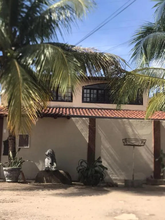 Fachada do Pendotiba Hostel com coqueiros
